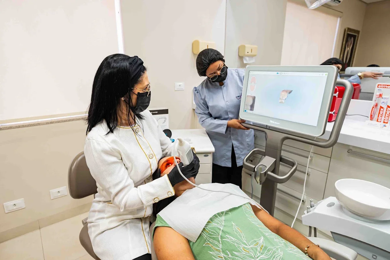 Dentista e auxiliar acompanham na tela o modelo 3D gerado pelo escaneamento intraoral