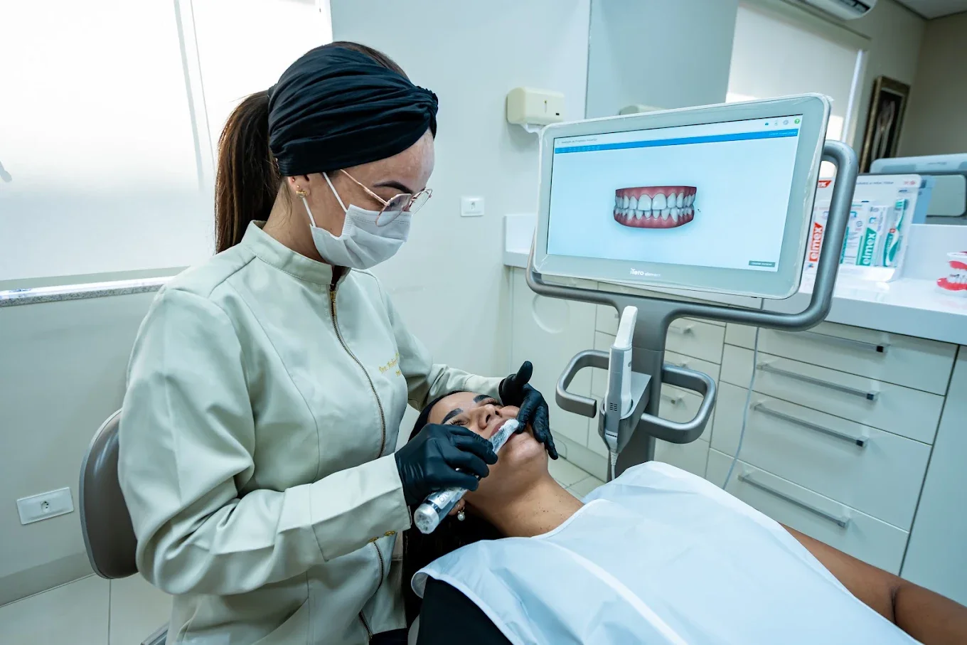 Dentista fazendo o escaneamento digital dos dentes de uma paciente no consultório da Croorto